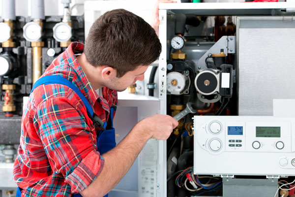 HVAC technician inspecting and repairing boiler controls in Fountain