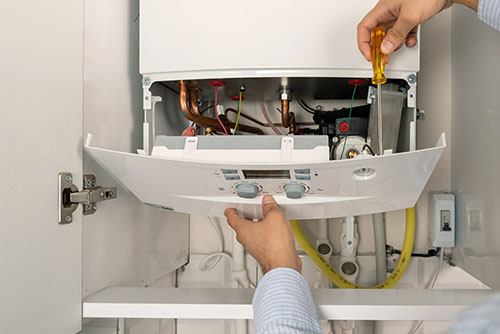 HVAC technician repairing an indoor boiler in Fountain