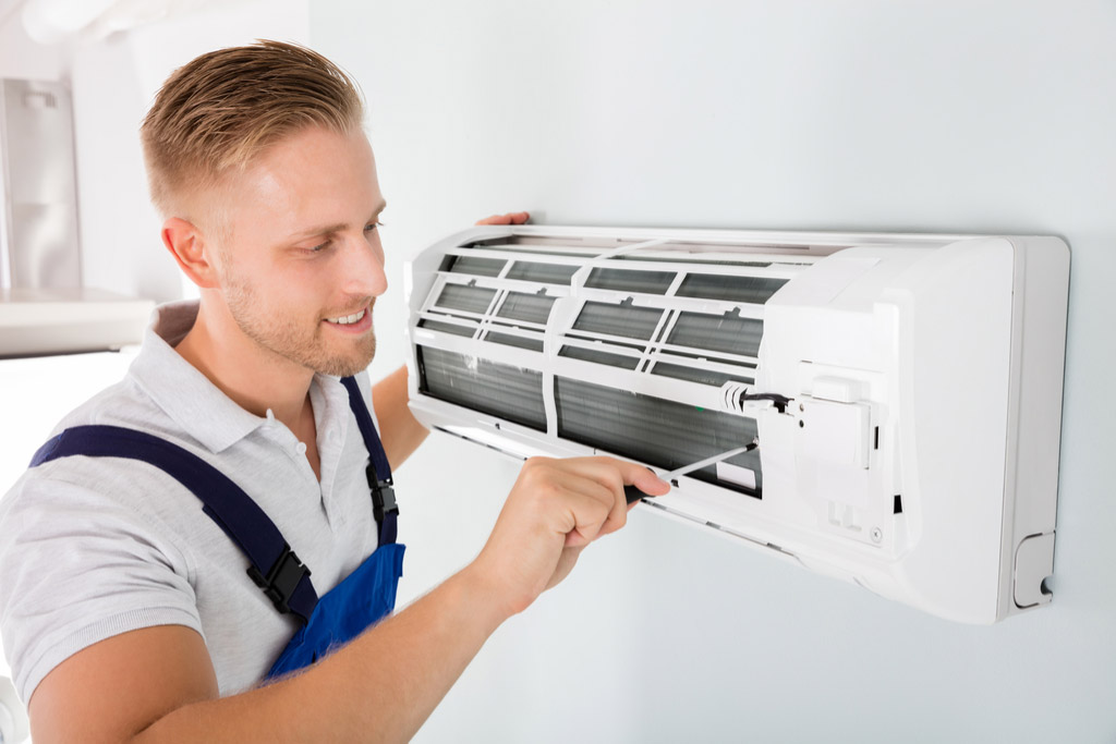 HVAC technician performing ductless air conditioning maintenance in Fountain