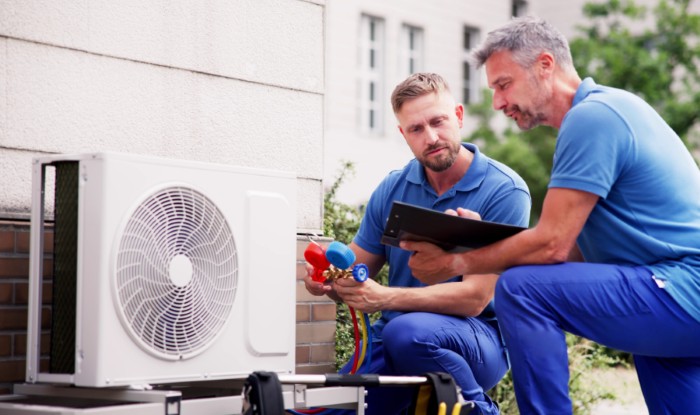 HVAC technicians installing an outdoor air conditioning unit in Fountain