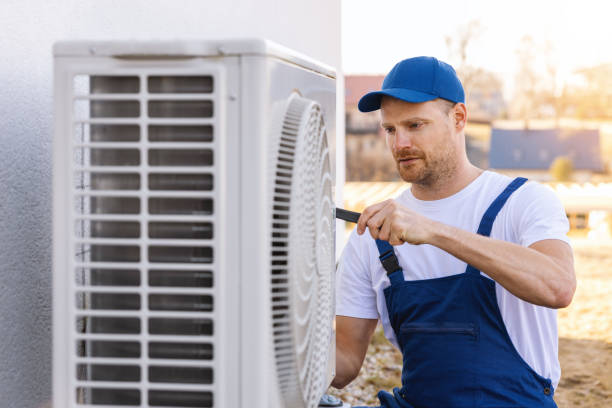 HVAC technician servicing an outdoor air conditioning unit in Fountain