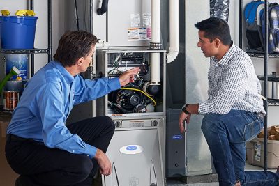 65df8c11f3e4c468cbd351a5_furnace repair vs replacement – Copy HVAC technician explaining furnace repair and maintenance to a homeowner in Fountain, CO
