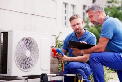 ac-installation-in-claremont-ca HVAC technicians reviewing an outdoor air conditioning unit in Fountain, CO