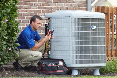 design-air-heating-and-air-conditioning-decatur-il-05 – Copy HVAC technician inspecting an outdoor air conditioning unit in Fountain, CO