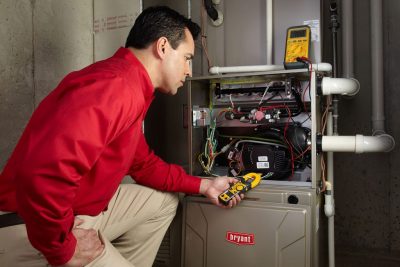 furnace repair Heating and air conditioning technician servicing an indoor furnace in Fountain, CO